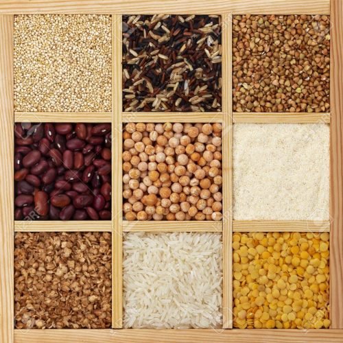 Different types of groats in square wooden box, collection of raw cereals, beans and seeds, top view textures